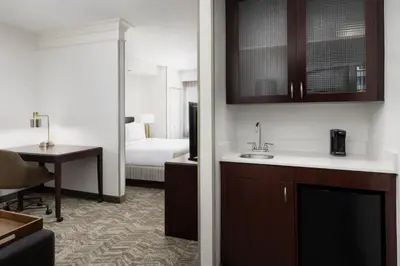 a hotel room with a kitchen and a bedroom at SpringHill Suites Fresno in Fresno