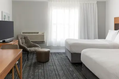a hotel room with two beds and a chair at TownePlace Suites by Marriott Sacramento Roseville in Roseville