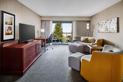a living room with a television and a couch and chair at Courtyard by Marriott Roseville Galleria Mall/Creekside Ridge Drive in Roseville