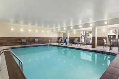 a pool in a hotel room with chairs and tables at Fairfield Inn by Marriott Tracy in Tracy