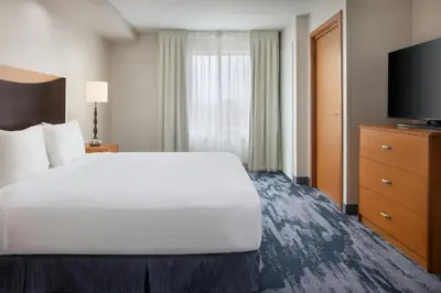 a hotel room with a bed and a flat screen tv at Fairfield Inn and Suites Turlock in Turlock