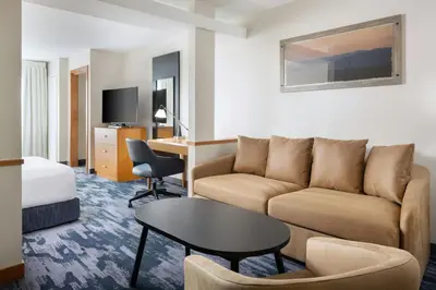 a hotel room with a couch and a table at Fairfield Inn and Suites Turlock in Turlock