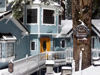 a blue house with a yellow door in the snow at Chateau Royal East in Yosemite West