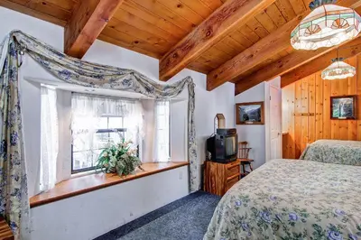 a bedroom with a bed and a window at Chateau Royal East in Yosemite West