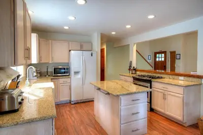 a large kitchen with white appliances and wooden floors at Alder Lodge in Yosemite West