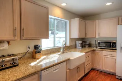 a kitchen with white cabinets and a sink and a window at Alder Lodge in Yosemite West