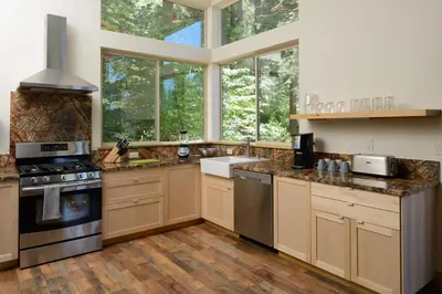 a kitchen with wooden cabinets and a large window at Alpenglow 2 in Yosemite West