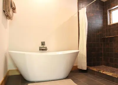 a white bath tub in a bathroom with a shower at Alpenglow 2 in Yosemite West