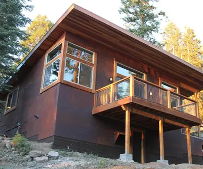 a house with a wrap around deck and windows at Alpenglow 3 in Yosemite West