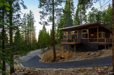 a house in the woods with a winding road at Alpenglow 3 in Yosemite West