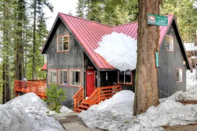 a small house with a red roof in the woods at Christmas Cabin in Yosemite West