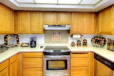 a kitchen with wooden cabinets and a stove top oven at Christmas Cabin in Yosemite West