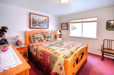 a bedroom with a wooden bed and a window at Christmas Cabin in Yosemite West