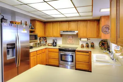 a kitchen with wooden cabinets and a stainless steel refrigerator at Christmas Cabin in Yosemite West