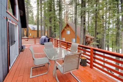 a deck with a table and chairs and a cabin at Christmas Cabin in Yosemite West