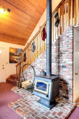 a brick fireplace in a room with a stove at Christmas Cabin in Yosemite West