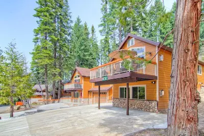 a large wooden house with a balcony on it at Explorers Retreat in Yosemite West