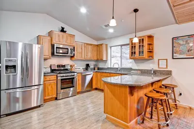 a large kitchen with wooden cabinets and stainless steel appliances at Explorers Retreat in Yosemite West
