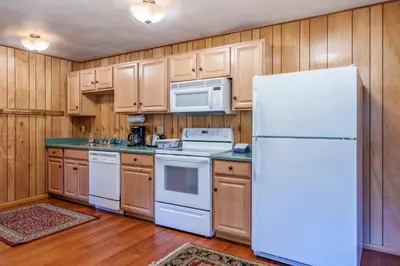 a kitchen with white appliances and wooden cabinets at Hutchings Cabin & Apt. in Yosemite West