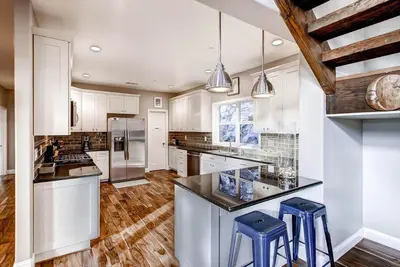 a large kitchen with white cabinets and blue stools at Kildrummy Lodge in Yosemite West
