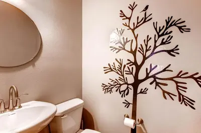 a bathroom with a tree stenciled on the wall at Kildrummy Lodge in Yosemite West
