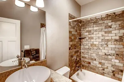 a bathroom with a sink and a tub and a toilet at Kildrummy Lodge in Yosemite West