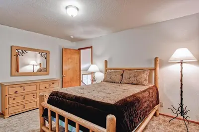 a bedroom with a bed and a dresser and a mirror at Little Sport in Yosemite West