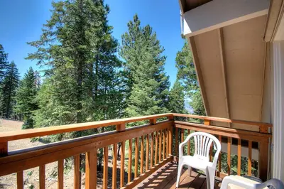 a porch with a white chair and some trees at Mystic Views in Yosemite West