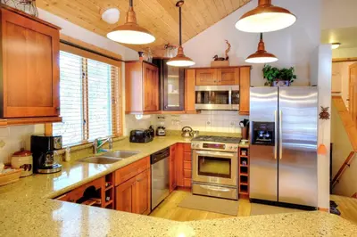 a kitchen with wooden cabinets and a stainless steel refrigerator at Strawberry Creek in Yosemite West