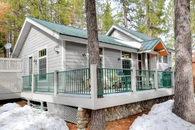 a tiny house in the woods with a wrap around porch at Strawberry Creek in Yosemite West