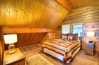a bedroom with a bed in a log cabin at Treetops Cabin in Yosemite West