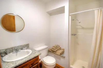 a bathroom with a sink and a toilet and a mirror at Treetops Cabin in Yosemite West