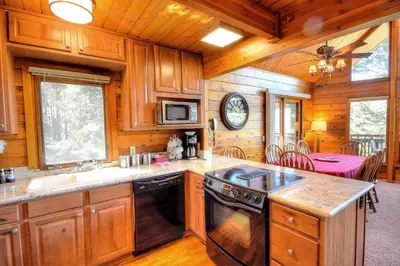 a kitchen with wooden cabinets and a stove at Treetops Cabin in Yosemite West