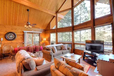 a living room with couches and a flat screen tv at Treetops Cabin in Yosemite West
