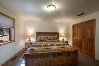 a bedroom with a large wooden bed with two lamps at Quail Crossing Lodge in Yosemite West