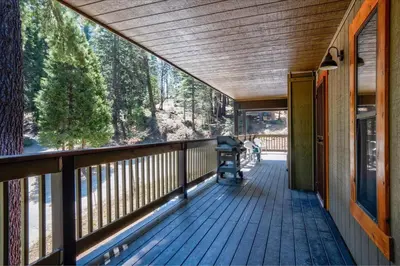 a screened porch with a view of the woods at Quail Crossing Lodge in Yosemite West