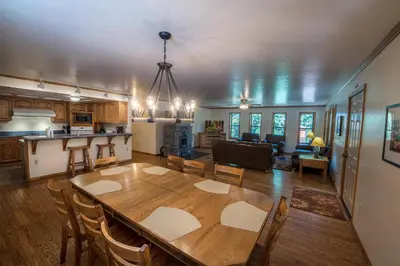 a kitchen and living room with a wooden table and chairs at Quail Crossing Lodge in Yosemite West