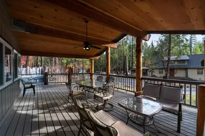 a wooden deck with tables and chairs on it at Starlight Lodge in Yosemite West