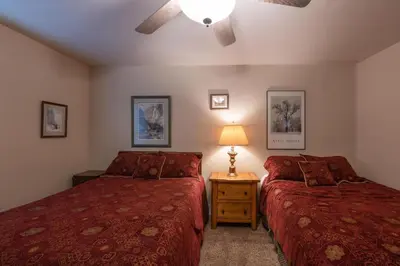 a bedroom with two beds and a lamp on a night stand at Starlight Lodge in Yosemite West