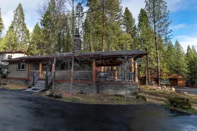 a cabin in the woods with a driveway at Starlight Lodge in Yosemite West