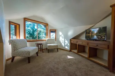 a living room with two chairs and a flat screen tv at Four Seasons in Yosemite West
