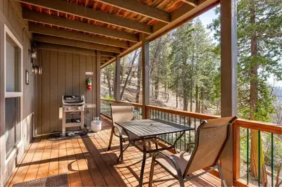 a screened in porch with a table and chairs at Falcons Nest (Downstairs) in Yosemite West