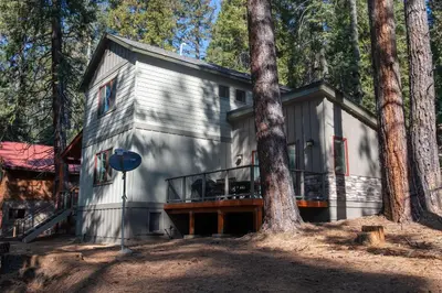 a house in the woods with a tree at Boulder Ridge in Yosemite West