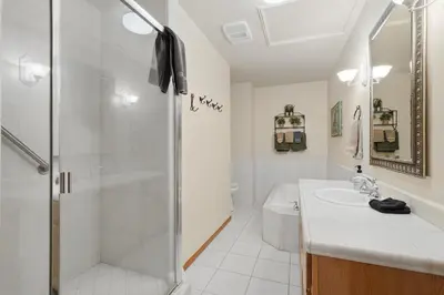a white bathroom with a shower and a sink at Apple Tree Bear House in Yosemite West