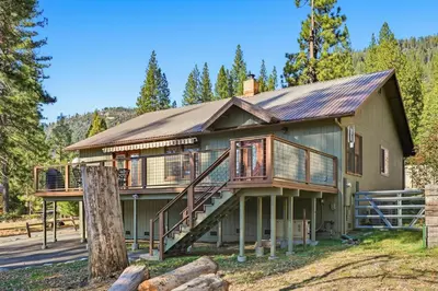 a house with a wrap around porch and a deck at Apple Tree Bear House in Yosemite West