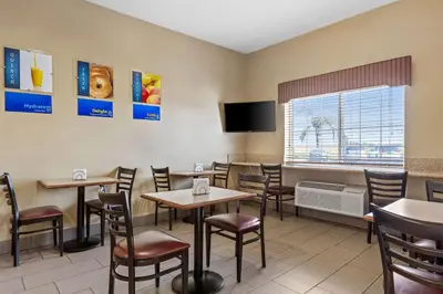 a restaurant with tables and chairs and a tv at Best Western Liberty Inn in Delano