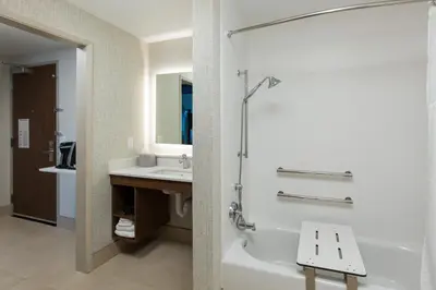 a bathroom with a bath tub and a sink at Holiday Inn Express Visalia-Sequoia Gateway Area by IHG in Visalia