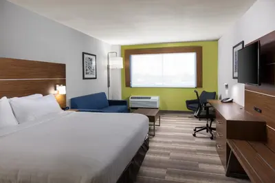a hotel room with a bed and a desk and a television at Holiday Inn Express Visalia-Sequoia Gateway Area by IHG in Visalia