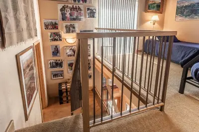 a spiral staircase in a living room with photos on the wall at Chamonix # 92 in Mammoth Lakes
