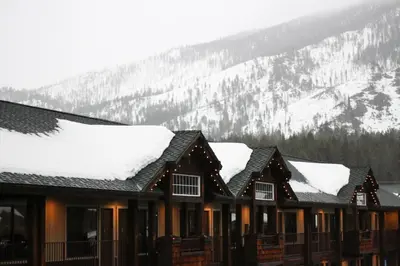 a building covered in snow with a mountain in the background at Hotel Becket, BW Signature Collection in South Lake Tahoe